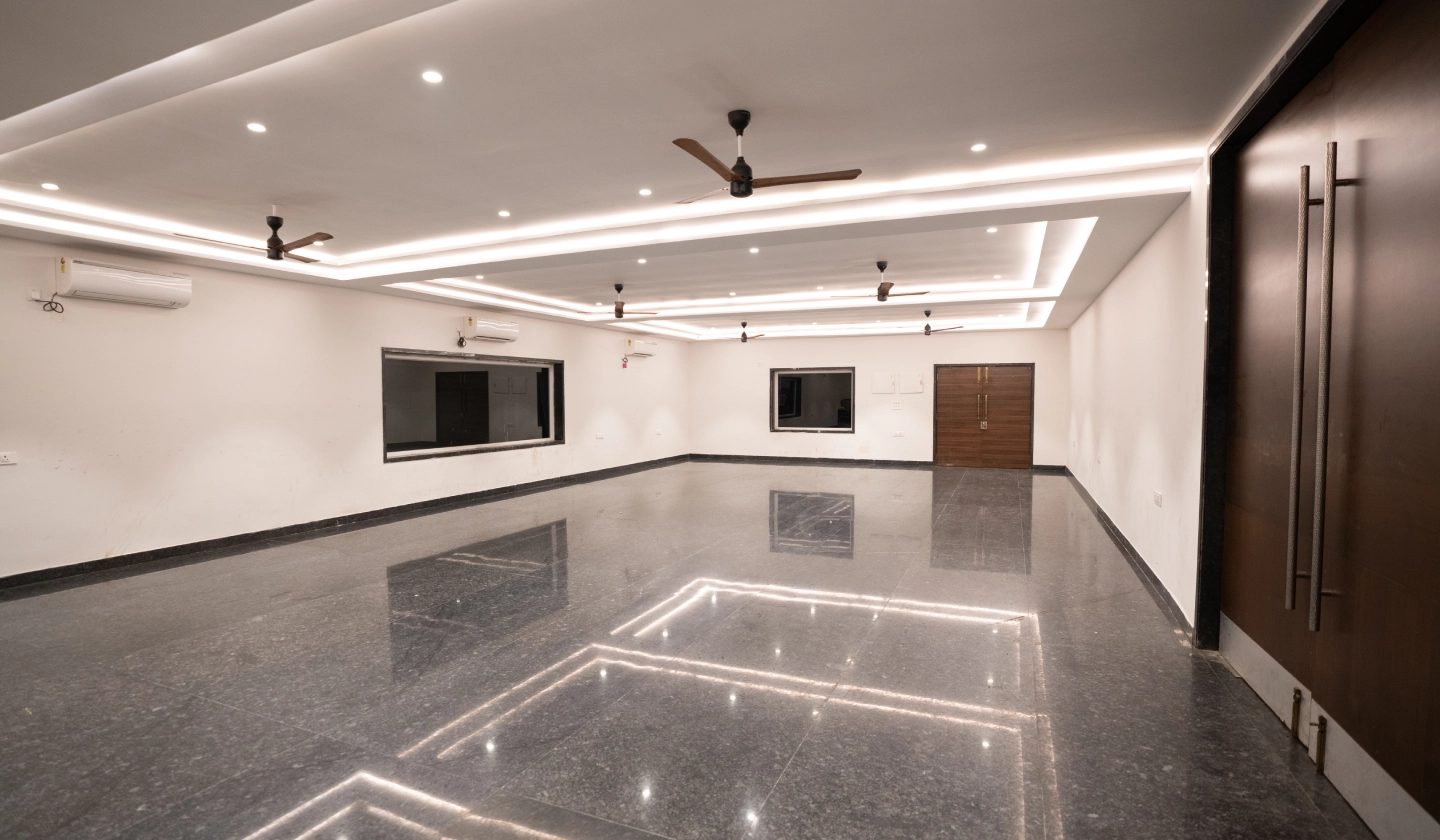 Pre-function lounge beside Ruby with white ceiling coves, a dark polished floor and ceiling fans